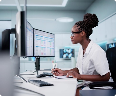 Healthcare professional managing clinical records at a workstation